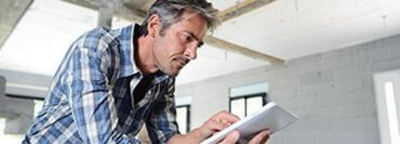 Teaser Handwerker am Smartphone arbeitet mit App